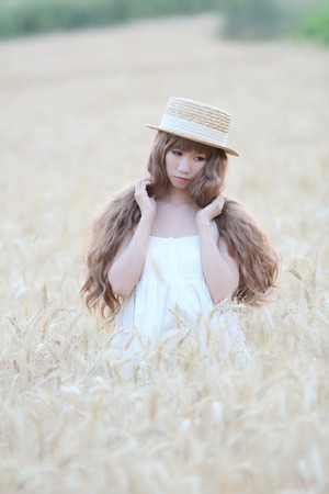 Asian girl on wheat fieldの写真素材