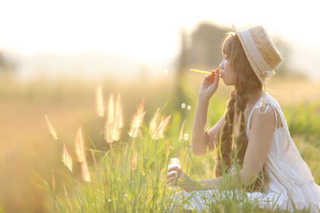 Asian girl on wheat fieldの写真素材