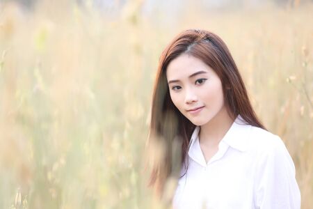 Asian girl on wheat fieldの写真素材