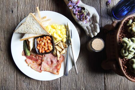 Breakfast with ham , fried egg and bread on wood background low keyの写真素材