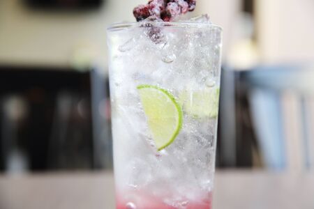 Berry cocktail with lime on wood background