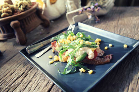 Baked potato with bacon and corn with mayo sauce on wood backgroundの写真素材
