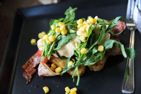 Baked potato with bacon and corn with mayo sauce on wood backgroundの写真素材