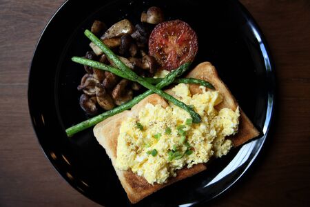 scrambled egg with bread and mushroom on wood backgroundの写真素材