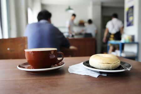 bagel with hot coffee on wood backgroundの写真素材