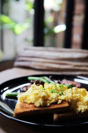 scrambled egg with bread and mushroom on wood backgroundの写真素材