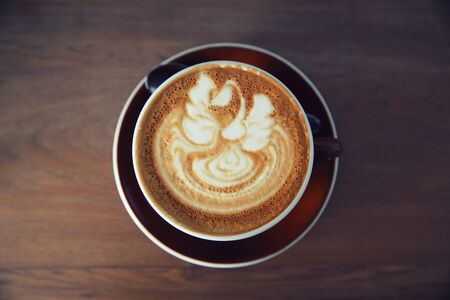 latte hot coffee on wood background in sepiaの写真素材