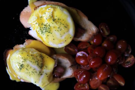 egg benedict in close up on wood backgroundの写真素材