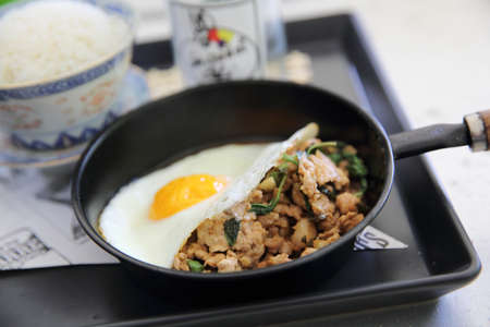 Stir fried pork and basil served with rice and fried egg , Thai food