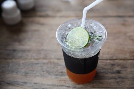 Ice tea with honey and lemon on wooden tableの写真素材