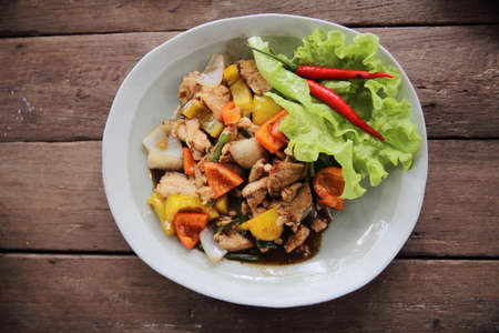 Stir fry chicken with black pepper on wood backgroundの写真素材