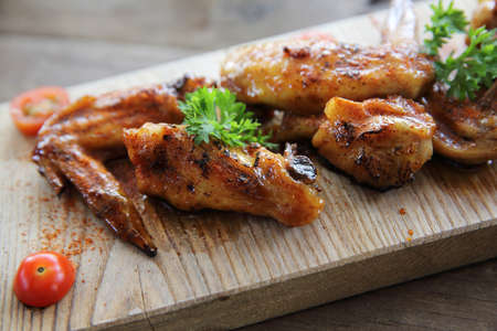 Grilled Chicken Wings with Red Spicy Sauce on wood backgroundの写真素材