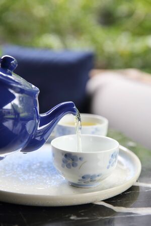 pouring tea into cup of tea in close up Chinese and Japan drinkの写真素材