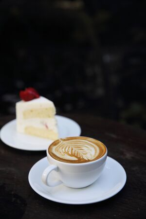 cappuccino coffee with cake on wood backgroundの写真素材