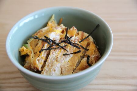 Japanese deep fried pork with egg on rice , Katsudon on wood backgroundの写真素材
