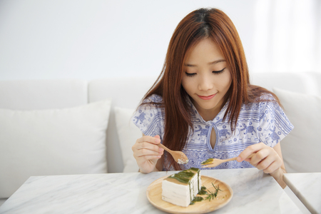 Young Asian Woman eating Green tea crape cake sweet foodの写真素材