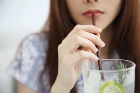 woman drinking lime juice in white coffeeshopの写真素材