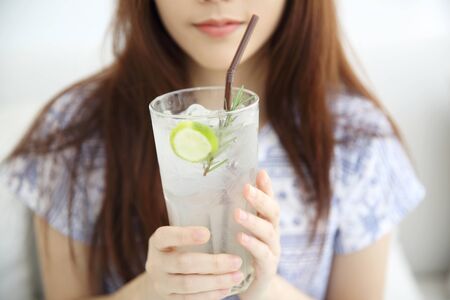 woman drinking lime juice in white coffeeshopの写真素材