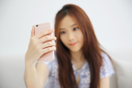 Young beautiful woman photo selfie in white toneの写真素材