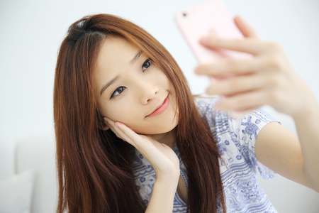 Young beautiful woman photo selfie in white toneの写真素材