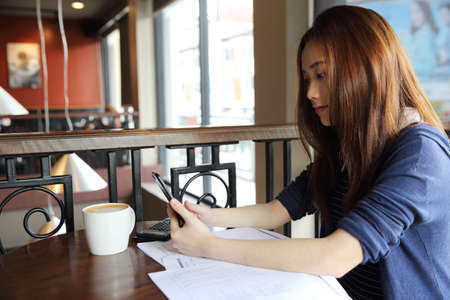 Young business woman with smartphone and coffeeの写真素材