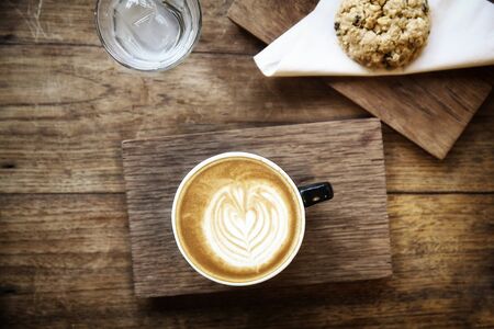 cappuccino coffee with cookie on wood backgroundの写真素材