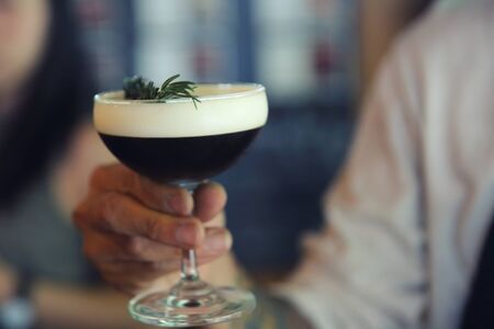 Coffee cocktail with coffee bean and rosemary on top with wood backgroundの写真素材