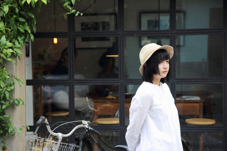 Asian young woman thinking and looking portrait with in coffee shopの写真素材