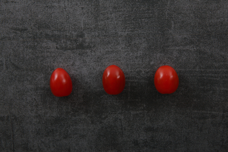 Tomatoes on dark rock backgroundの写真素材