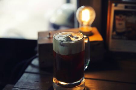 Coffee cocktail with coffee bean and rosemary on top with wood backgroundの写真素材