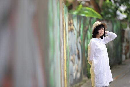 Asian young woman thinking and looking portrait with green tree backgroundの写真素材