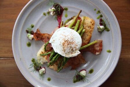 eggs benedict poached egg on bacon asparagus and bread breakfastの写真素材