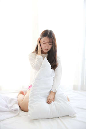 Asian young woman smiling on white bedroomの写真素材