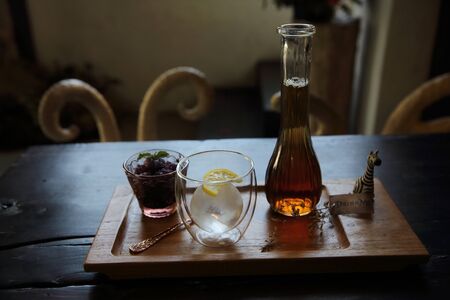 Berries tea with ice ball on wood background