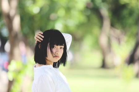 Asian young woman portrait with the tree backgroundの写真素材