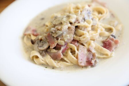 pasta fettuccine alfredo white sauce with ham bacon and mushroomの写真素材