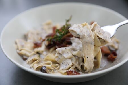 pasta fettuccine alfredo white sauce with ham bacon and mushroomの写真素材