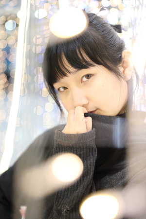 Young pretty girl wearing black cotton sweatshirt on bokeh background at night