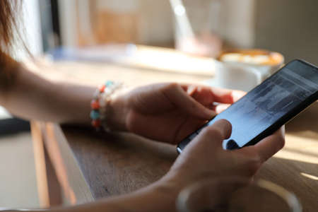 Woman hand shopping with phone on coffee shopの写真素材