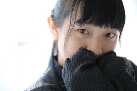 Young pretty girl wearing black cotton sweatshirt on bedroom white toneの写真素材