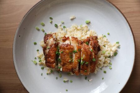 Nasi goreng fried rice with chicken on wood background in top viewの写真素材