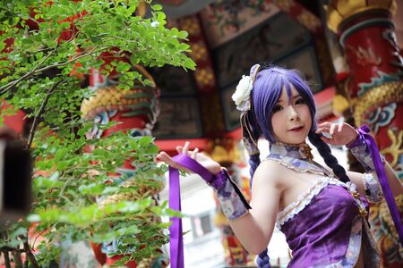 Portrait of asian young woman dancing with purple Chinese dress cosplay with templeの写真素材