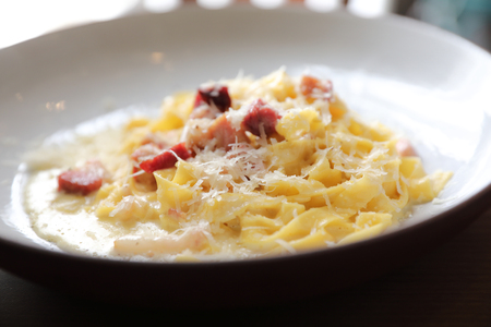 spaghetti carbonara white sauce with bacon on wood background in restaurantの写真素材