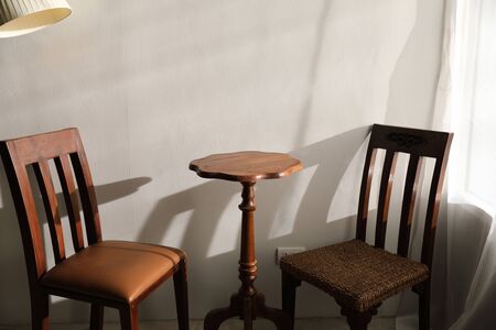 Wooden table and chairs with lamp on wallの写真素材