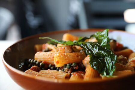Pasta with sausage in tomato sauce on wood background , italian foodの写真素材