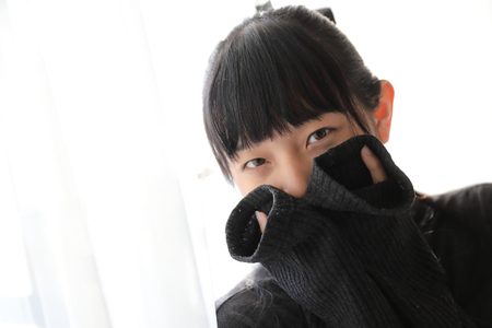 Young pretty girl wearing black cotton sweatshirt on bedroom white toneの写真素材
