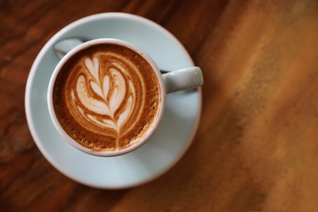 cappuccino or Latte art coffee made from milk on the wood table in coffee shopの写真素材