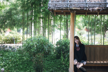Portrait of asian japanese school girl costume looking at park outdoor film vintage styleの写真素材