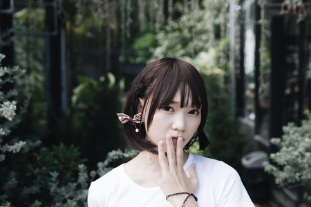 portrait of asian girl with white shirt and skirt looking in outdoor nature vintage film styleの写真素材