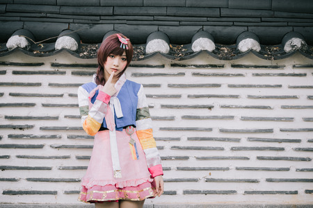 Portrait of Hanbok costume young woman looking and smile in korean parkの写真素材